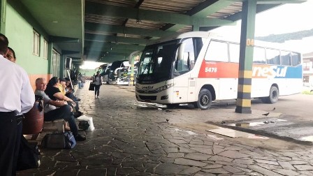 Rodoviária de Osório com ônibus e passageiros em bancos à espera